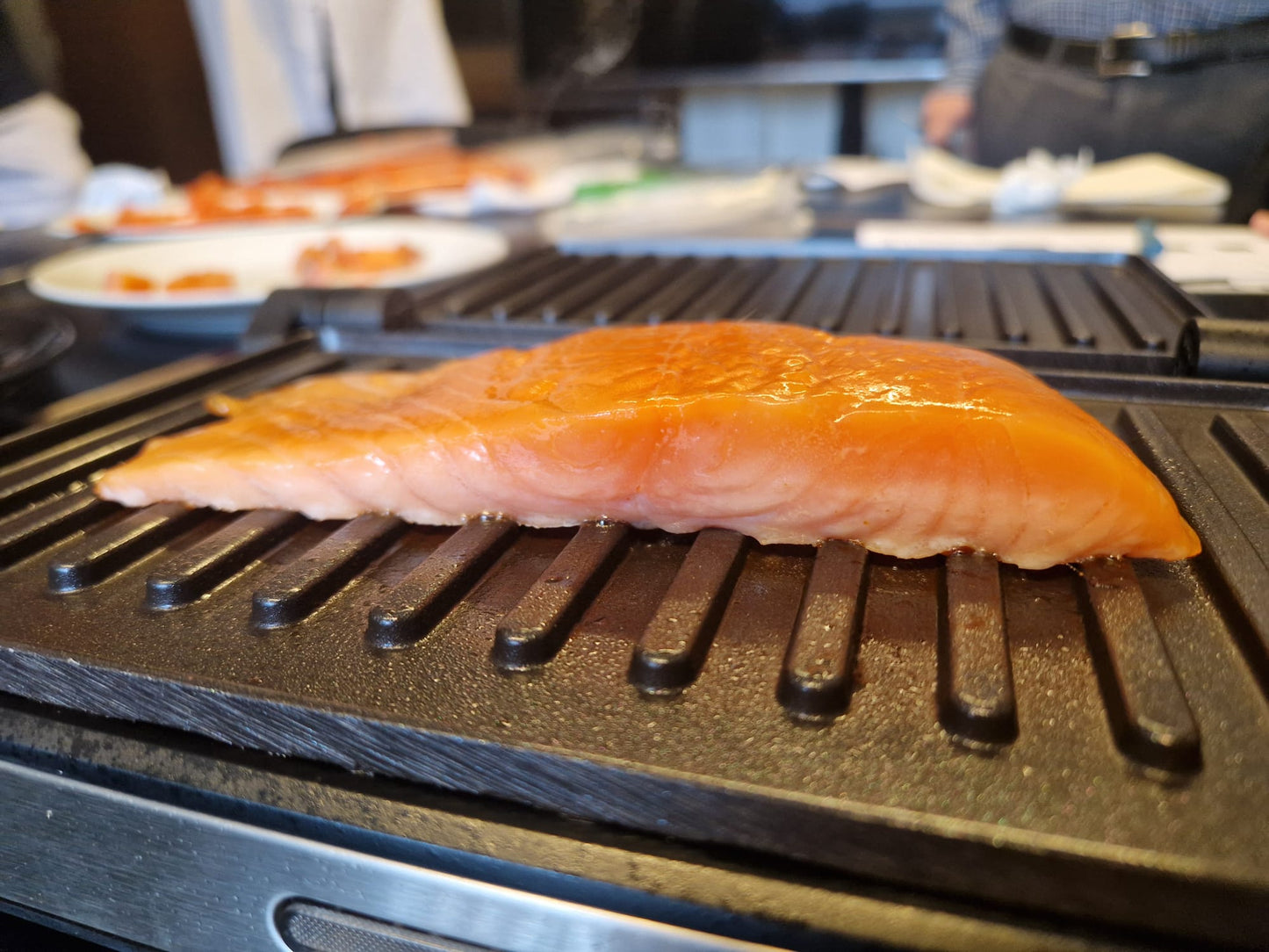 Pavé de saumon demi salé, demi fumé, de Maison Vendsyssel en train d'être snacké sur une plancha. 